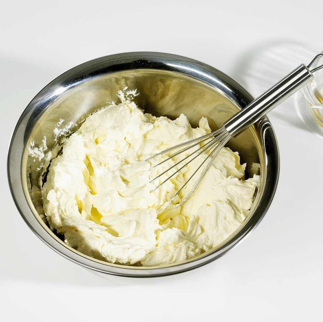 Käsekuchenteig wird mit Schneebesen gerührt