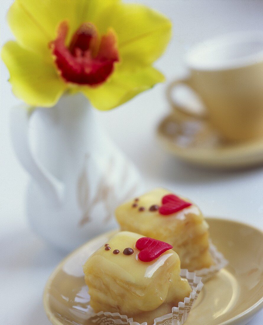 Zwei Petit fours mit einer Orchidee im Hintergrund