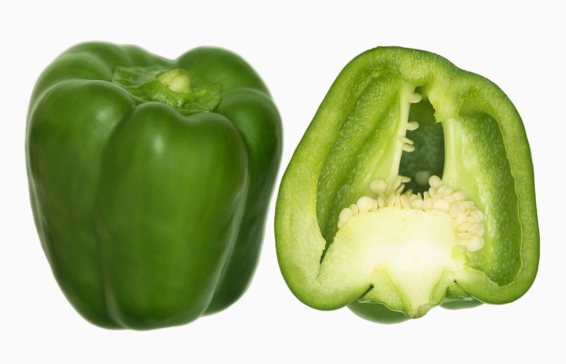 Ein ganzer und ein halber grüner Paprika