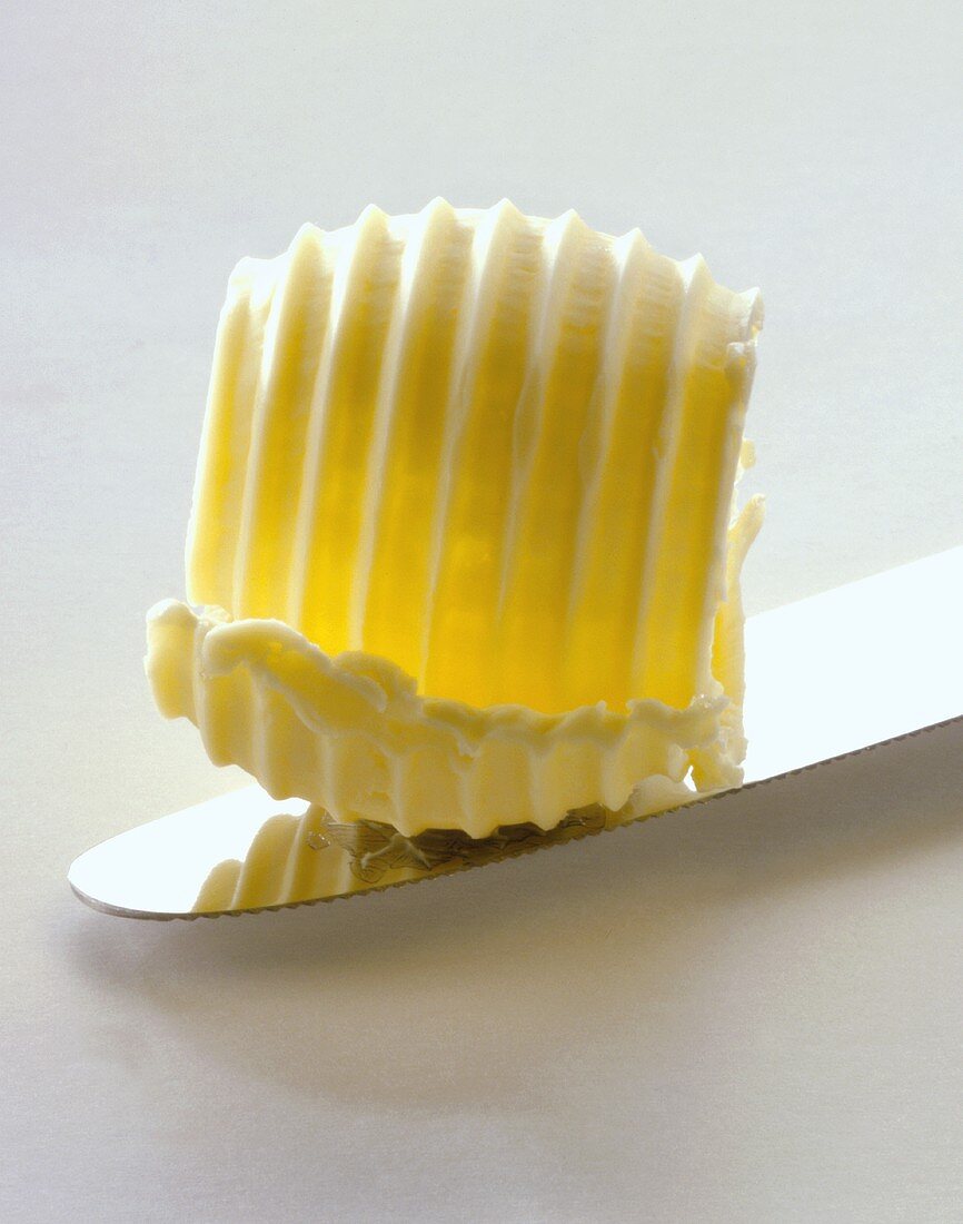 A butter curl on a knife (close-up)
