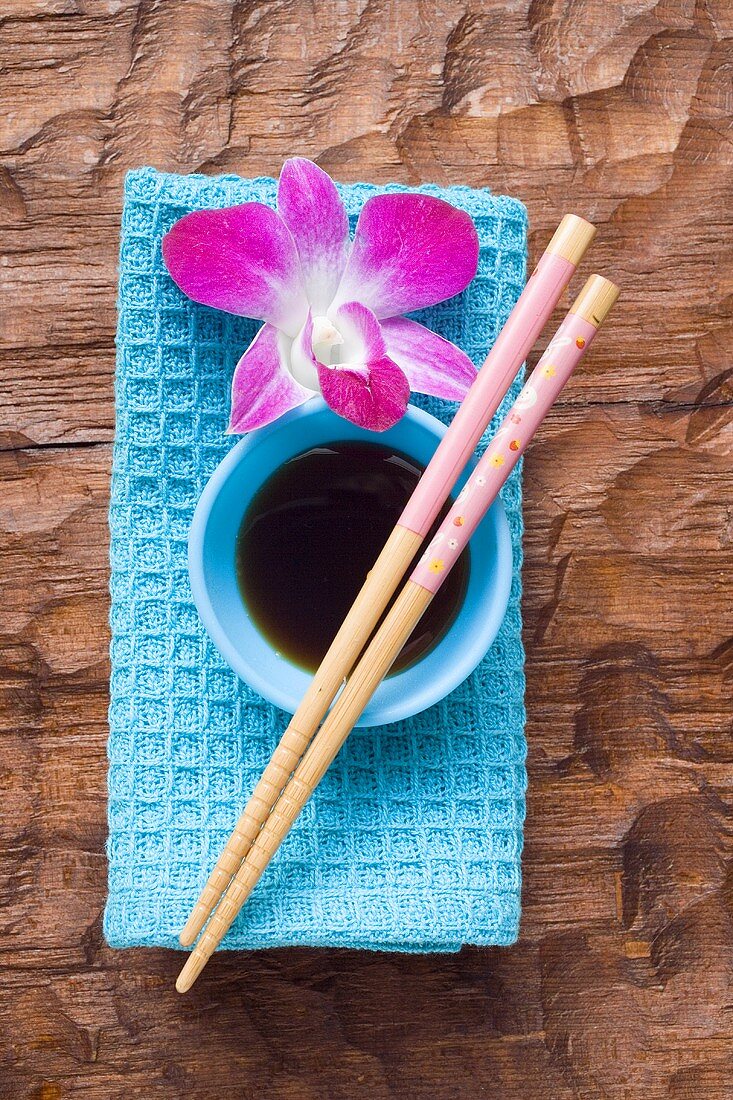 Still life with soy sauce, chopsticks, orchid & hand towel