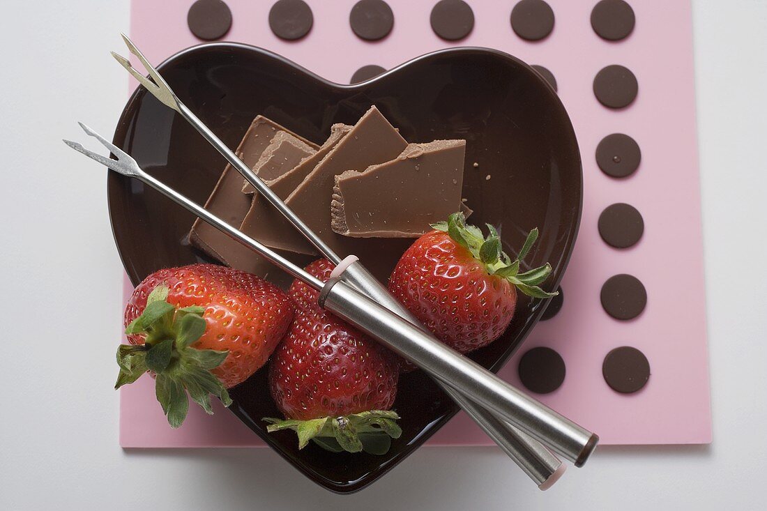 Schälchen mit Schokoladenstücken, Erdbeeren & Fonduegabeln