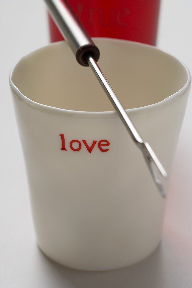 Beaker with the word 'love' and fondue fork