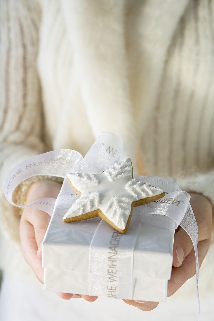 Woman holding Christmas gift with cinnamon star