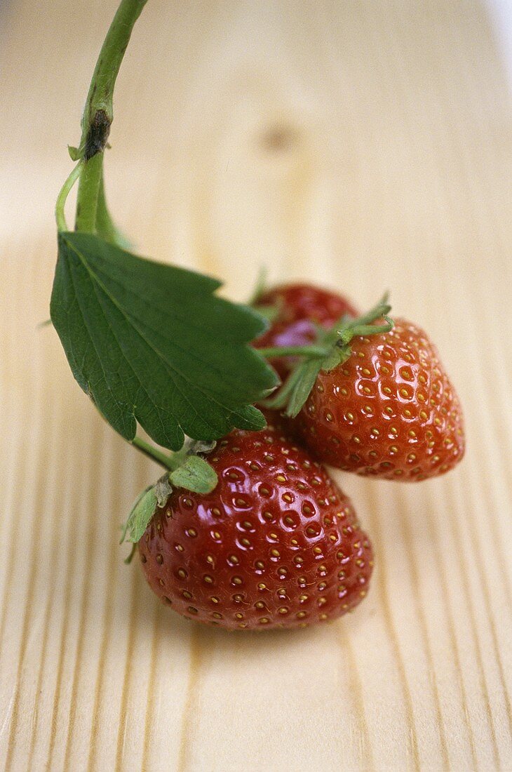 Strawberries with leaf on wooden background