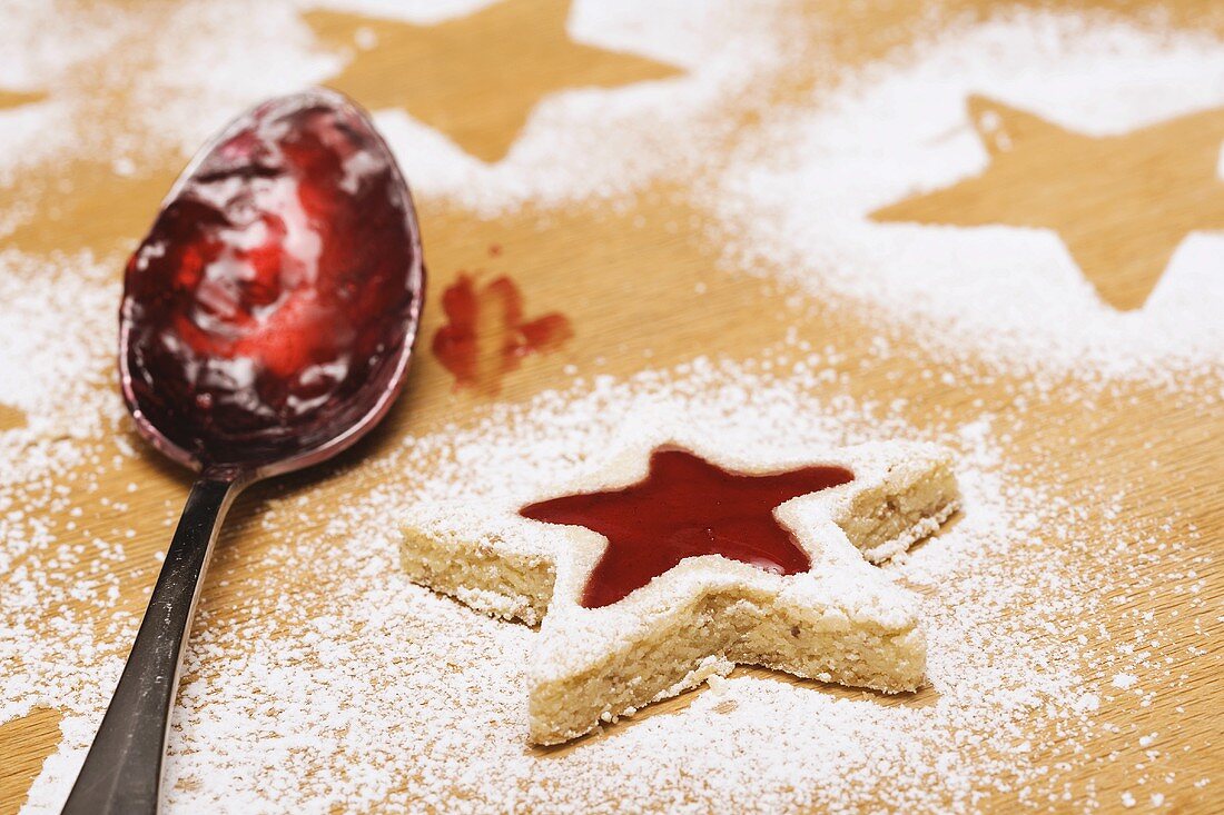 Star-shaped biscuit with jam filling and spoon with jam