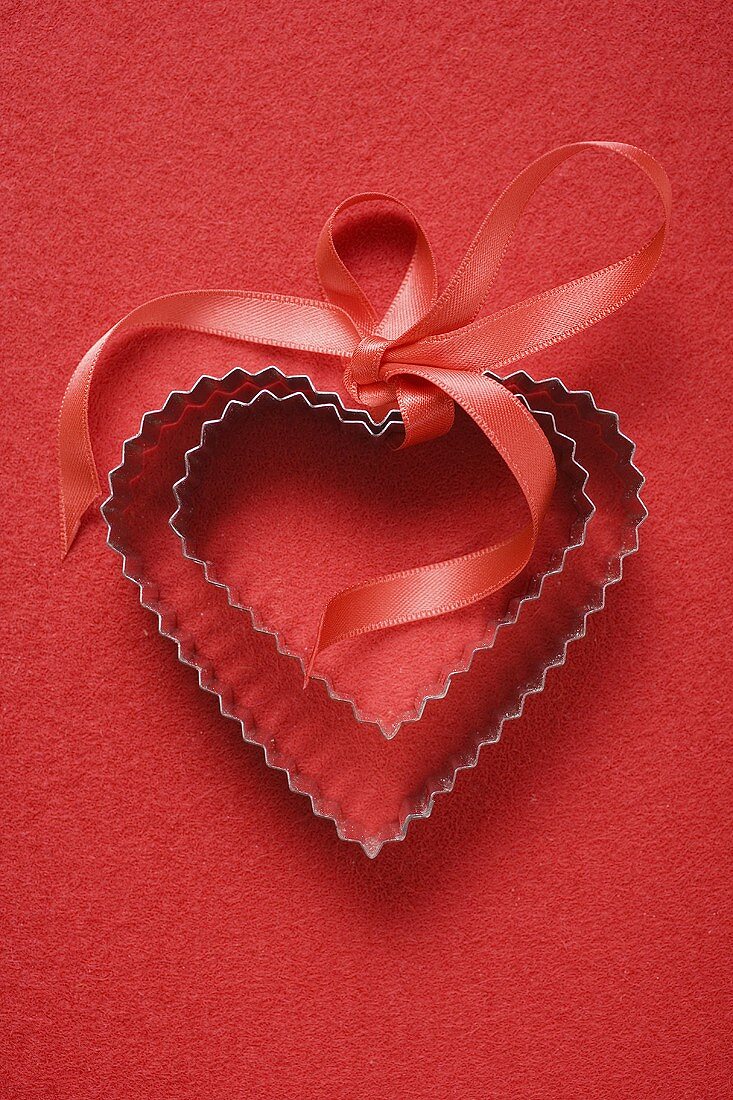 Heart-shaped biscuit cutters with red gift ribbon