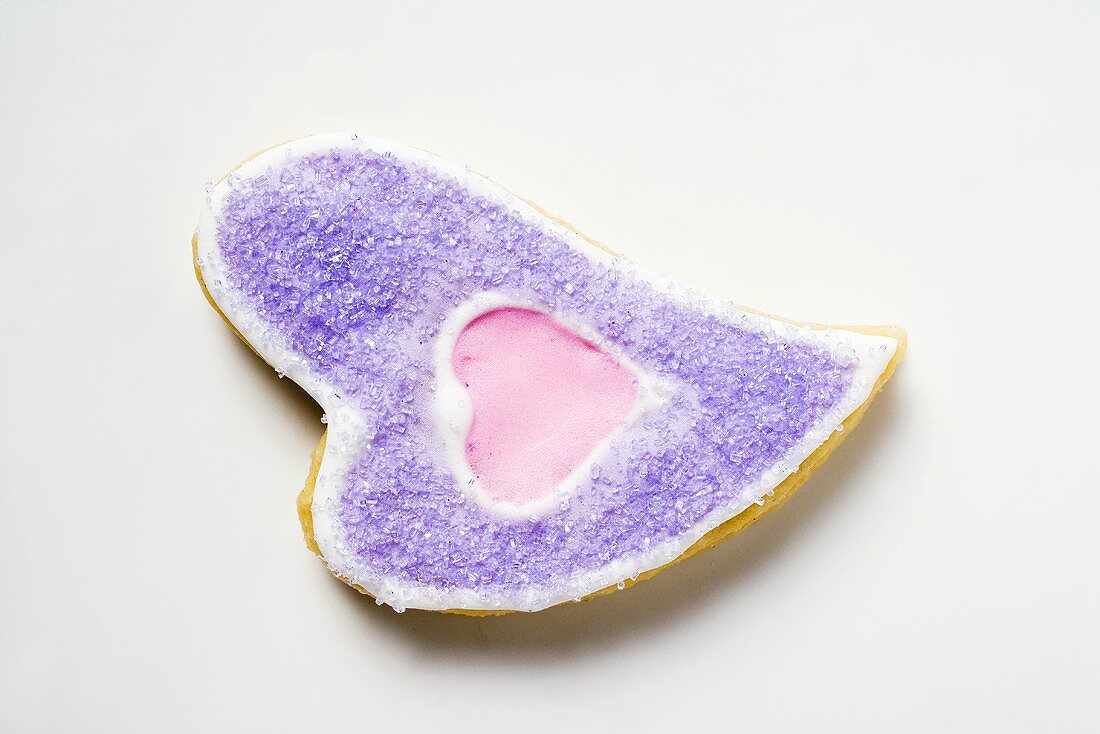 Herzförmiges Plätzchen mit lila Zucker verziert