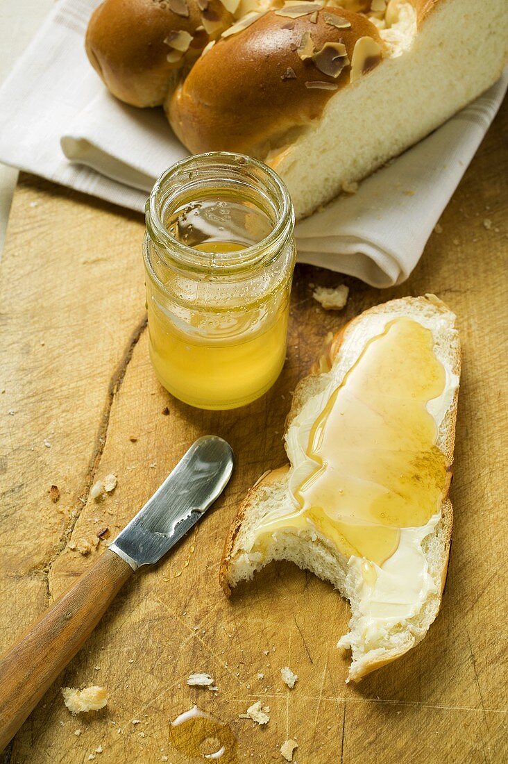 Slice of bread plait with butter and honey, a bite taken