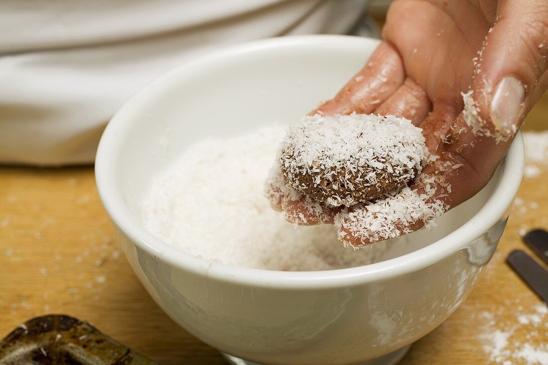 Coating a biscuit in grated coconut