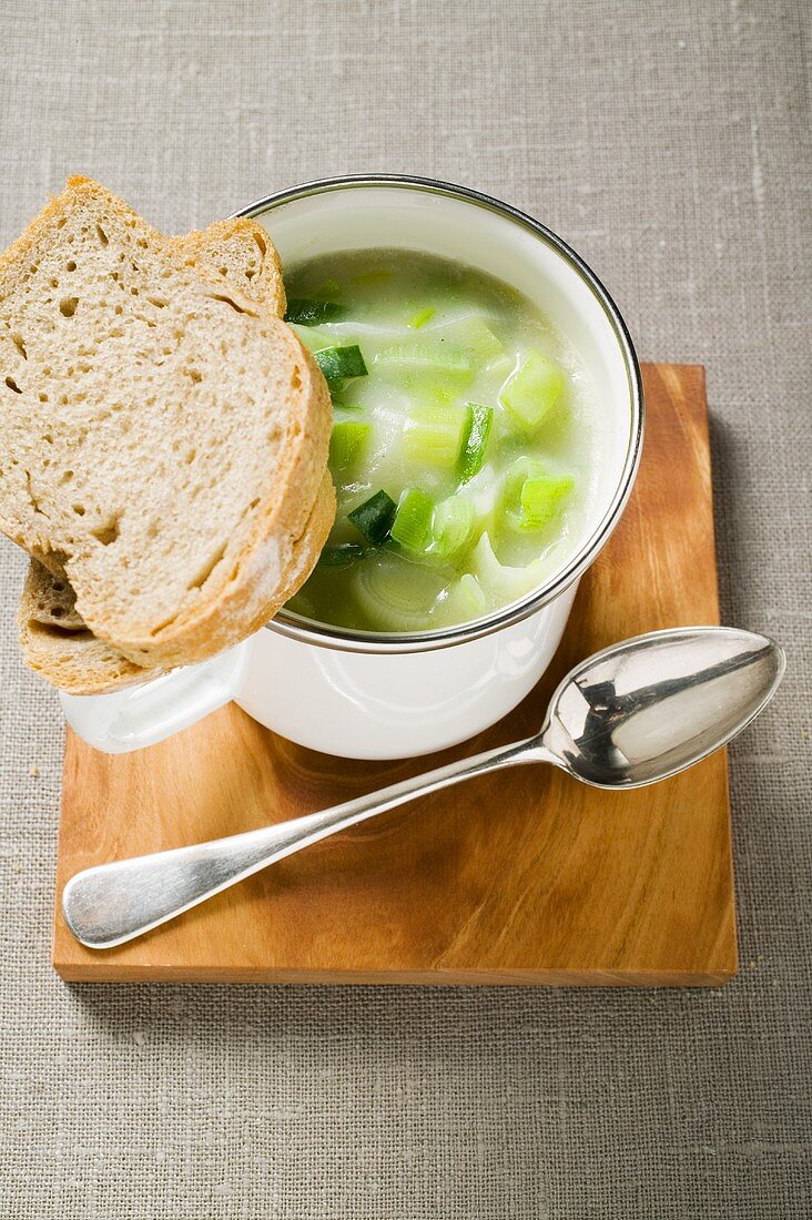 Lauchcremesuppe mit Brot und Löffel