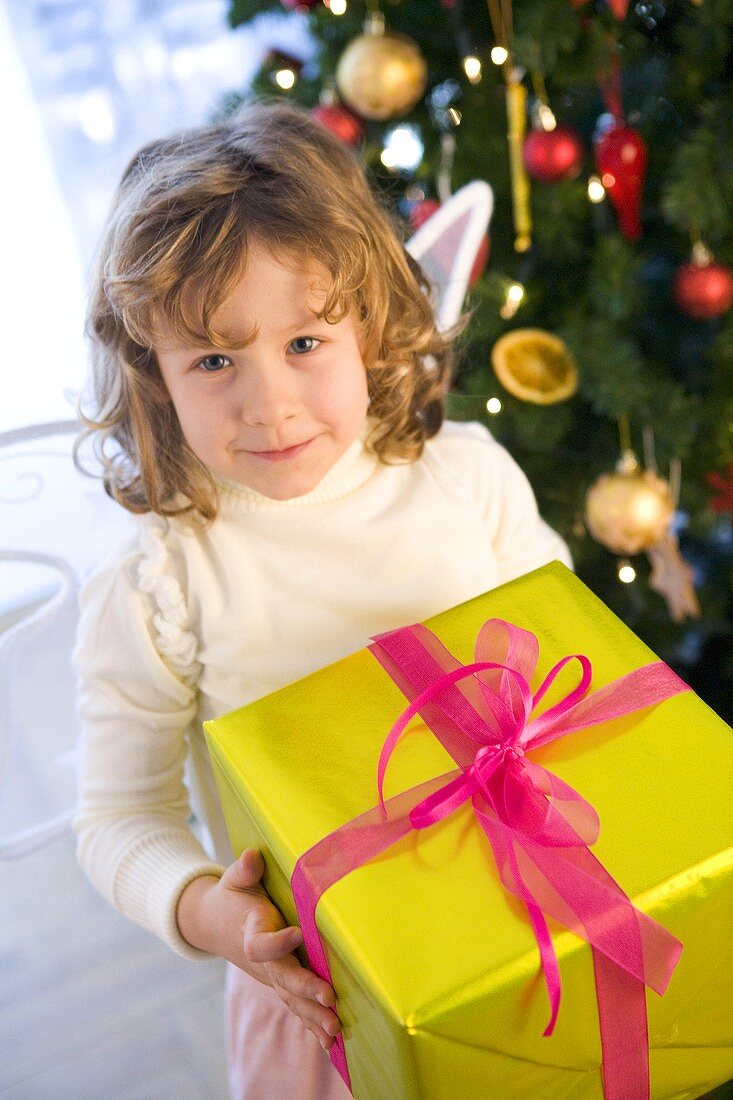Girl dressed as angel with Christmas gift