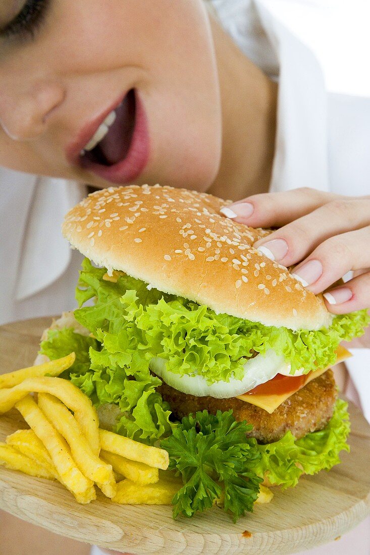 Young woman about to take a bite of hamburger