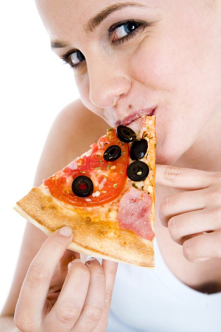 Young woman eating a slice of pizza