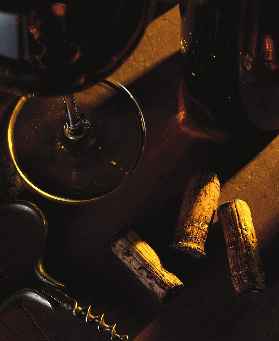 Stillleben mit Rotwein, Weinkorken und Korkenzieher