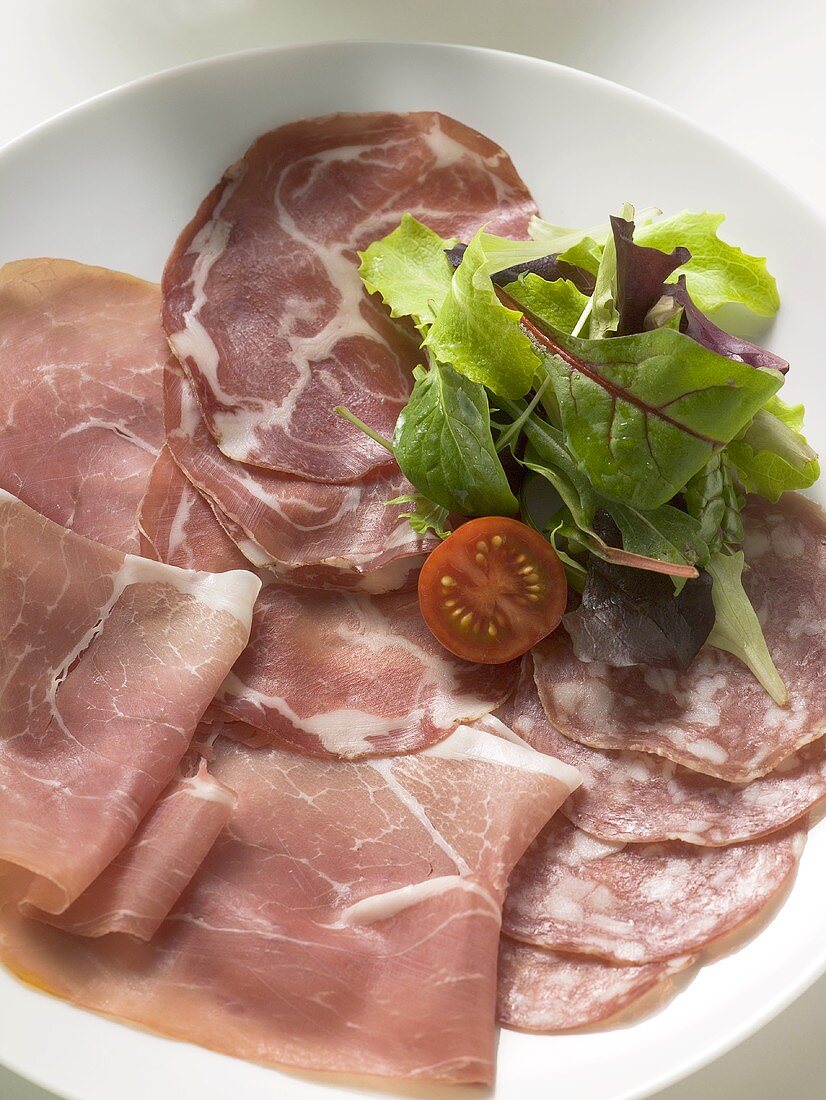 Verschiedene italienische Schinkensorten mit Salatdeko