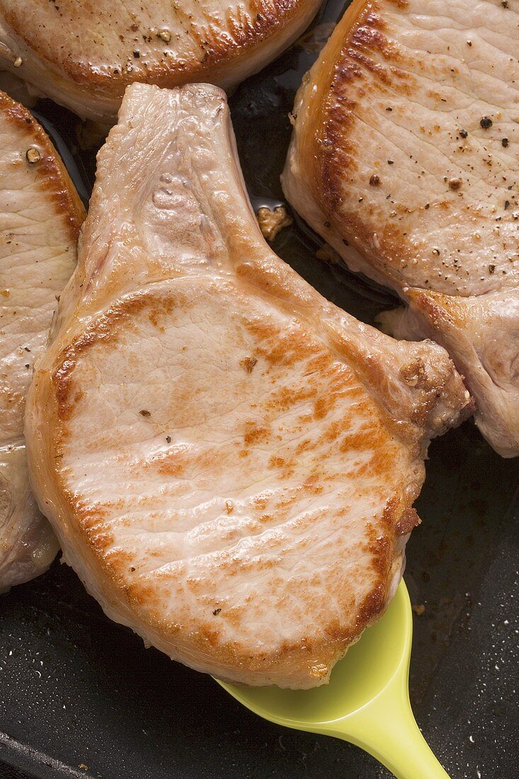 Fried pork chops in frying pan