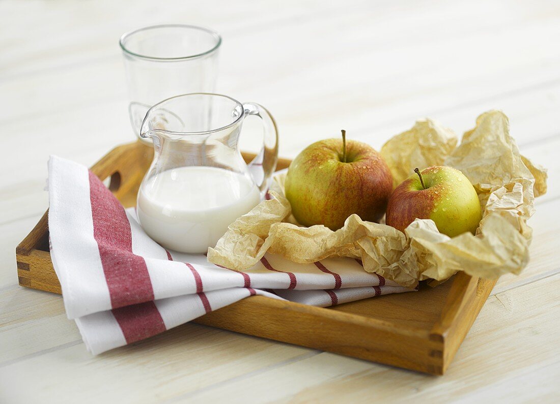 Tablett mit Äpfeln und Milch