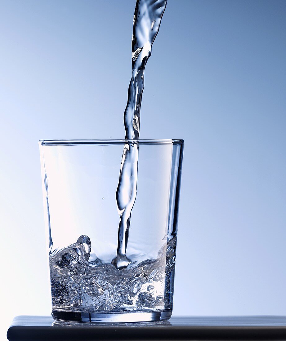 Wasser ins Glas gießen