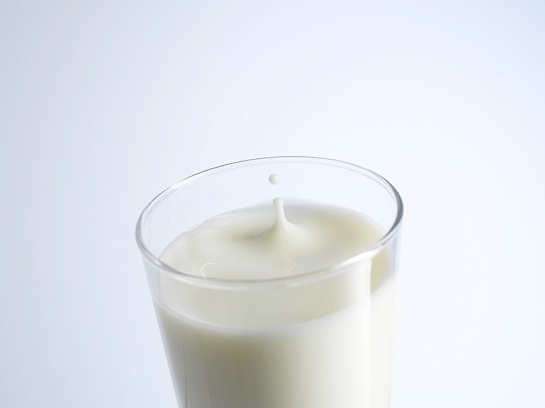 Ein Glas Milch mit einem Milchtropfen