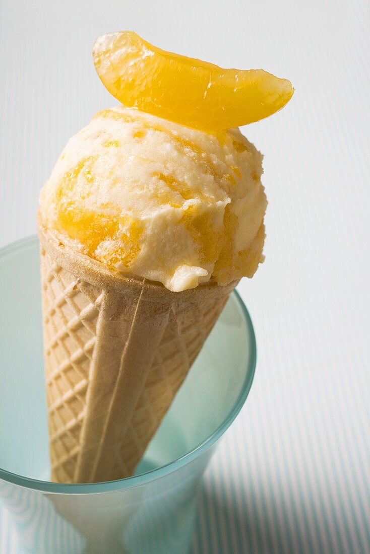 Orange ice cream in wafer cone in a beaker