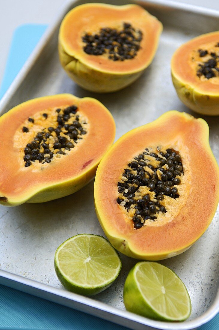 Halved papayas and lime