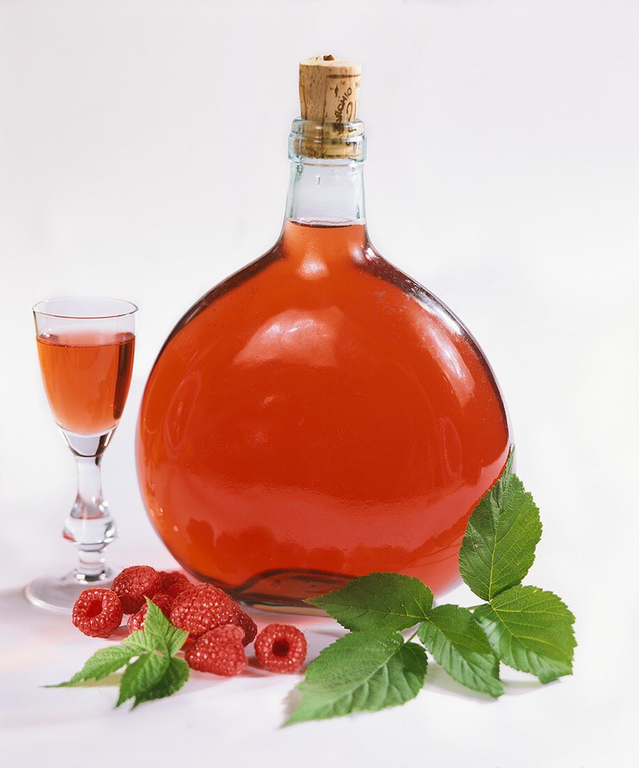 Bottle and glass of raspberry liqueur