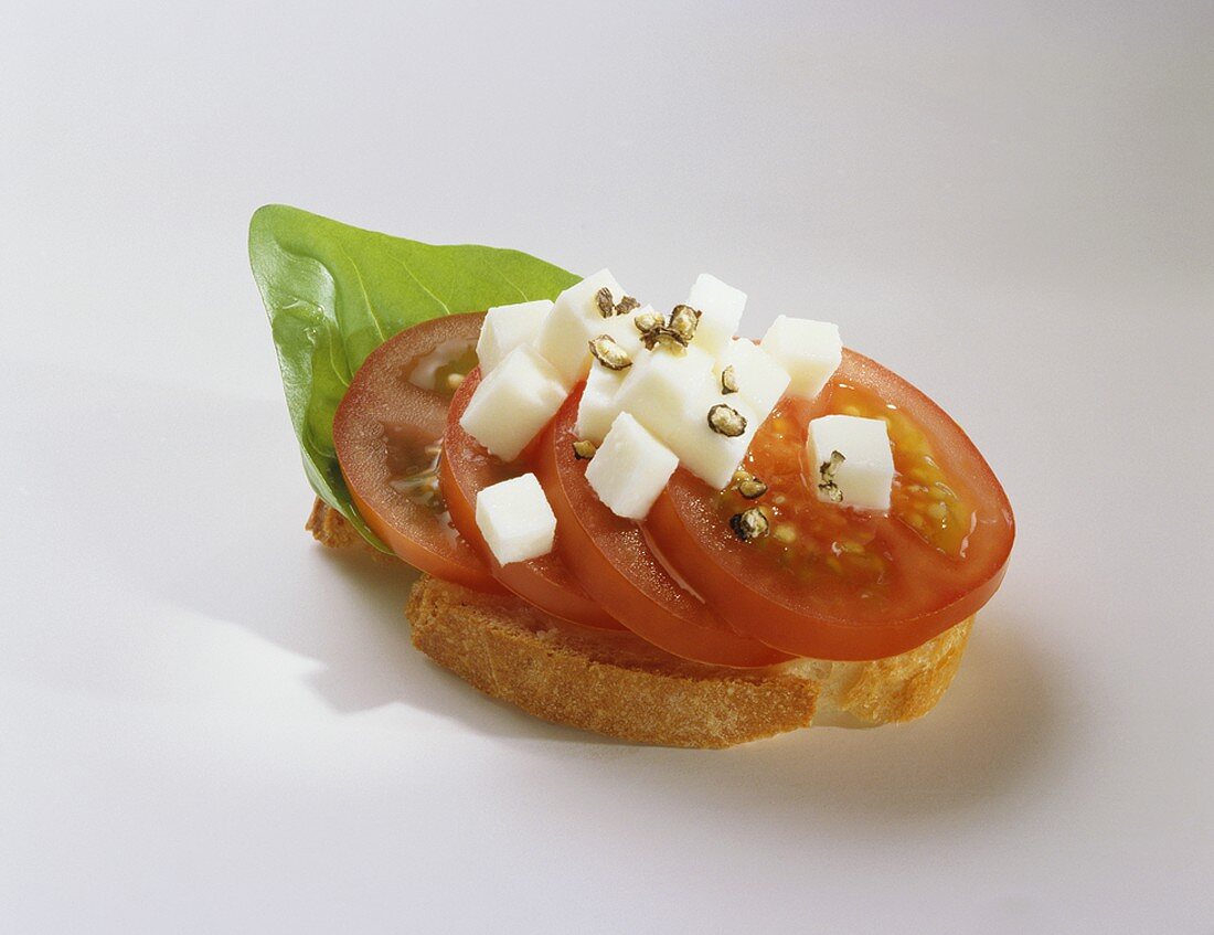 Canape: Baguettescheibe mit Tomaten, Mozzarella und Basilikum