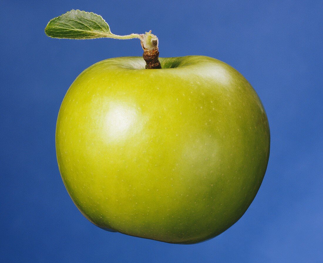 Ein grüner Apfel mit Blatt