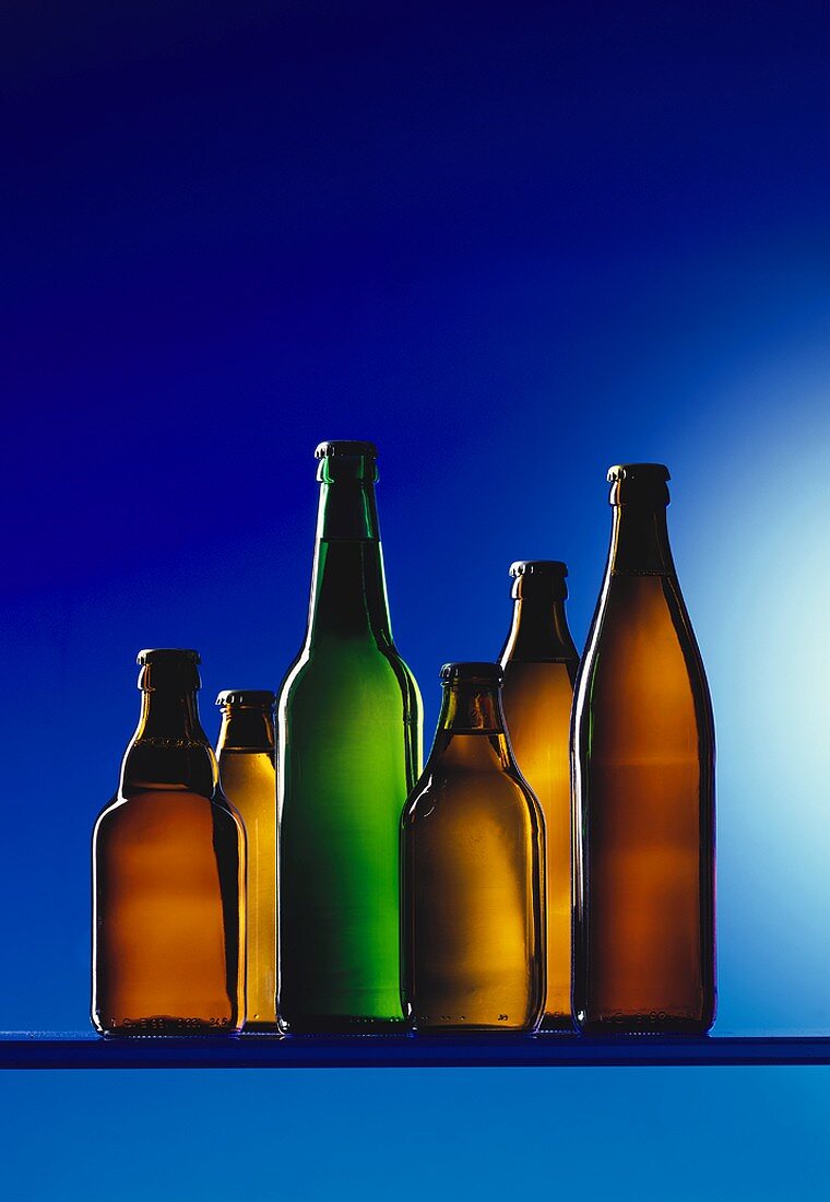 Verschiedene Bierflaschen vor blauem Hintergrund