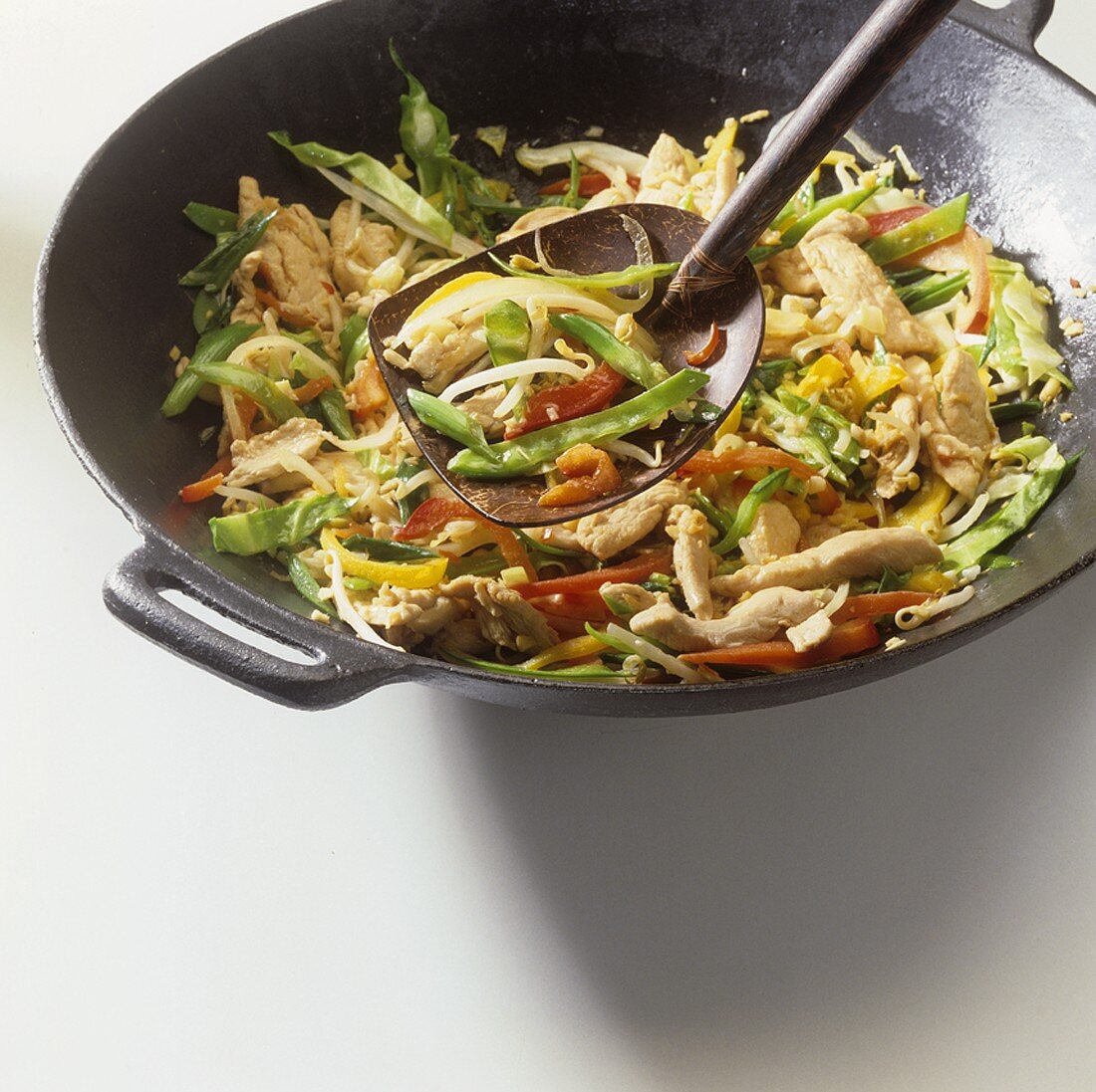Strips of chicken breast and vegetables in wok