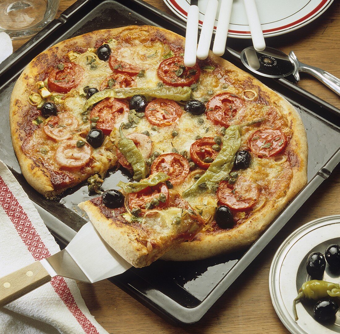 Wholemeal pizza topped with tomatoes, olives and chillies