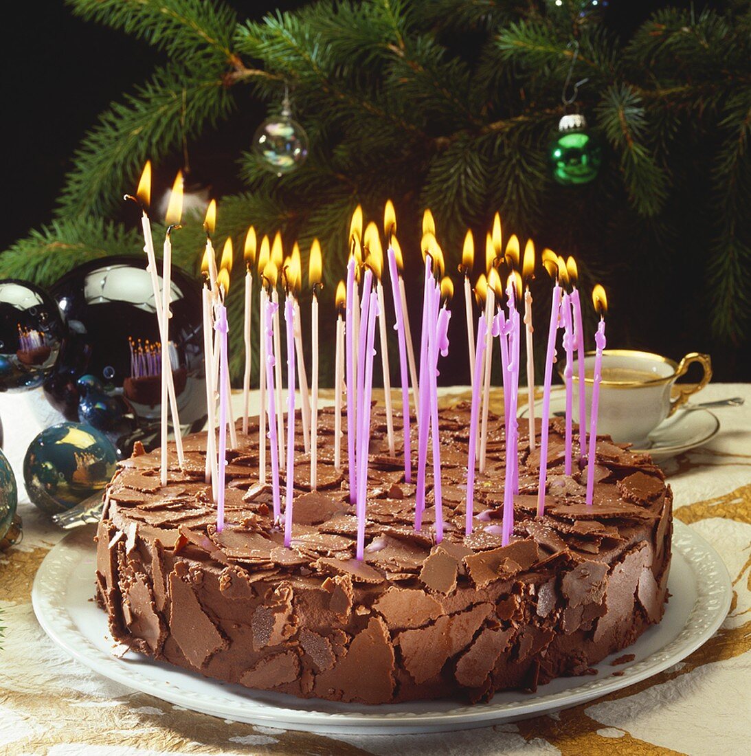 Chocolate cake with many burning candles