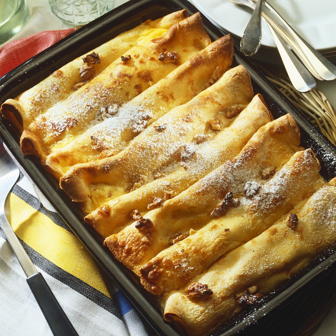 Crêpes with vanilla cream and nuts in baking dish