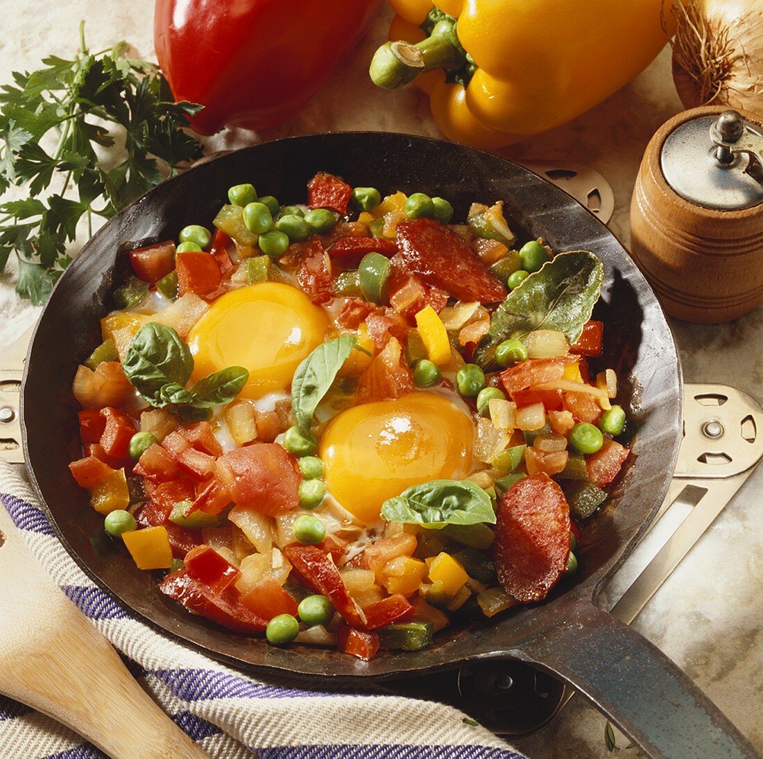 Fried eggs, vegetables and sausage in frying pan