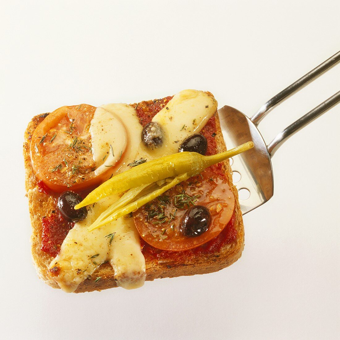 Toastscheibe mit Peperoni, Tomate und Käse überbacken