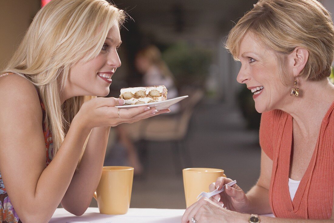 Zwei Frauen in einem Café mit einem Stück Tiramisu