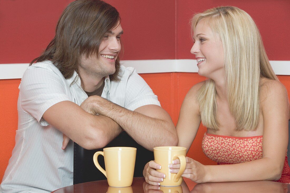 Blondes Mädchen und ein junger Mann im Café oder Restaurant