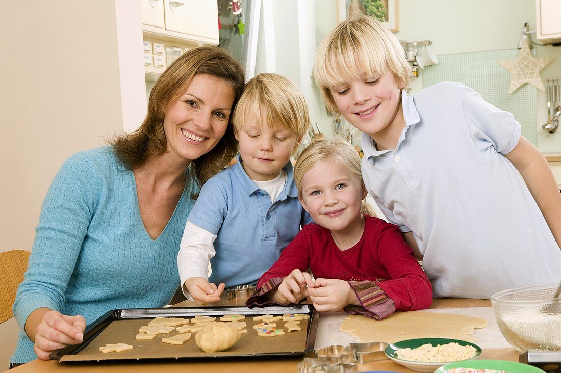 Mother and three children baking biscuits