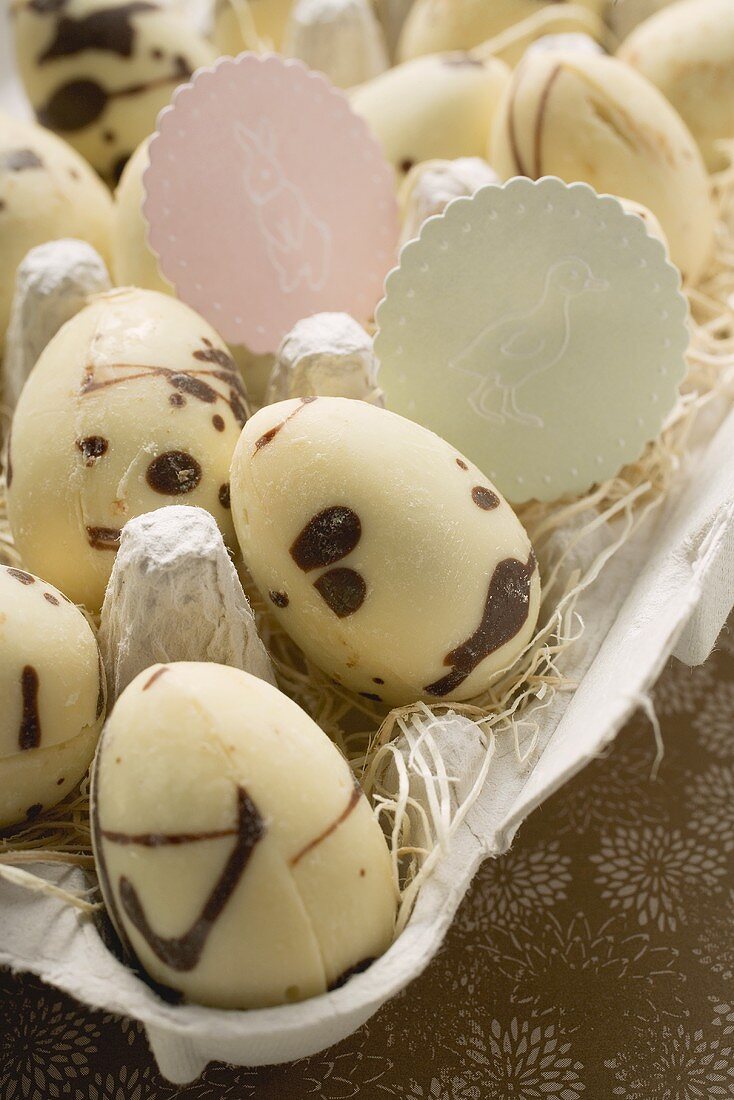 Speckled chocolate eggs in an egg box (close-up)
