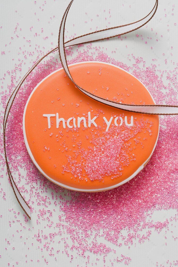 Ein orangefarbener Keks mit Aufschrift 'Thank You'