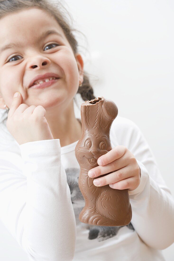 Girl holding chocolate Easter Bunny with its ear bitten off