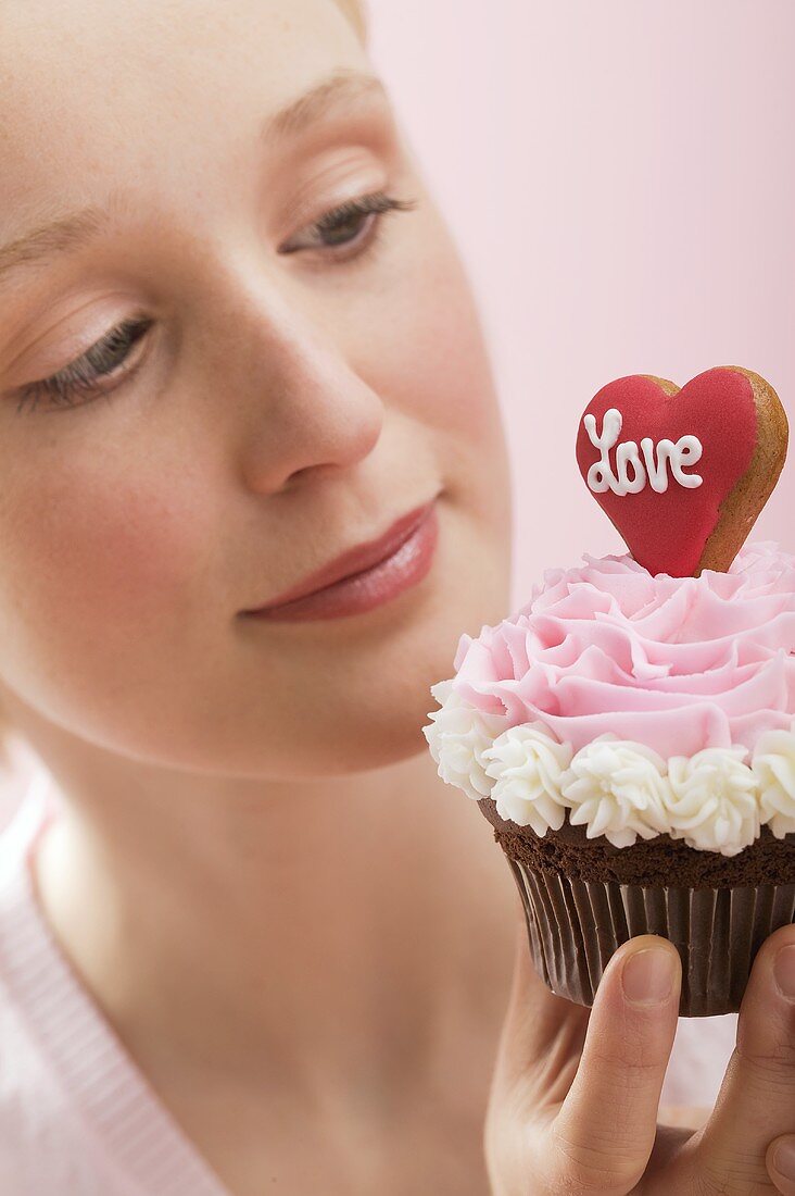Junge Frau mit einem Cupcake (Valentinstag)