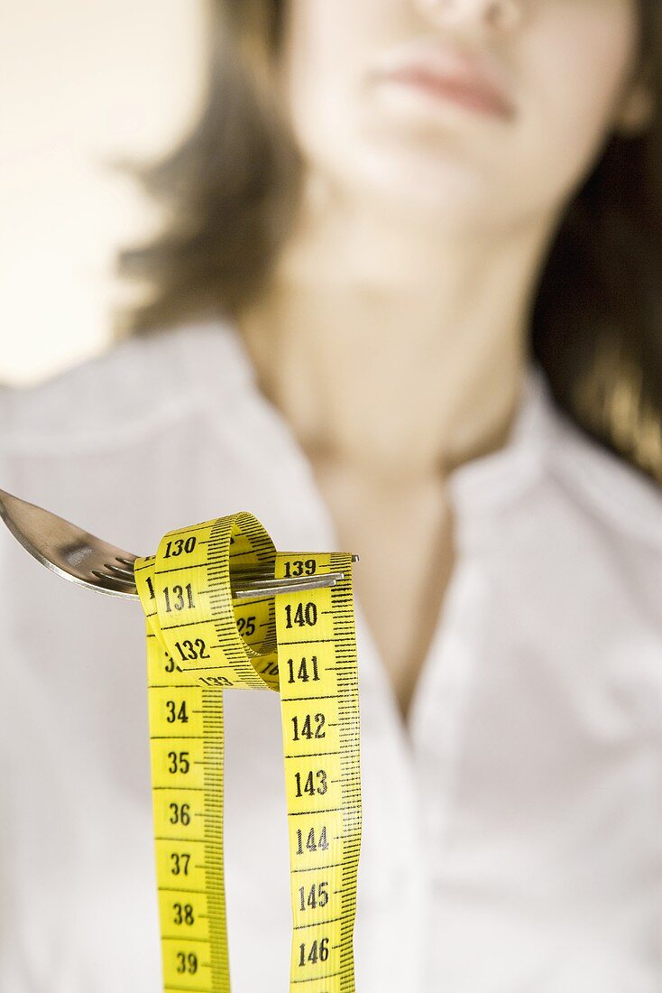 Woman holding a tape measure on a fork
