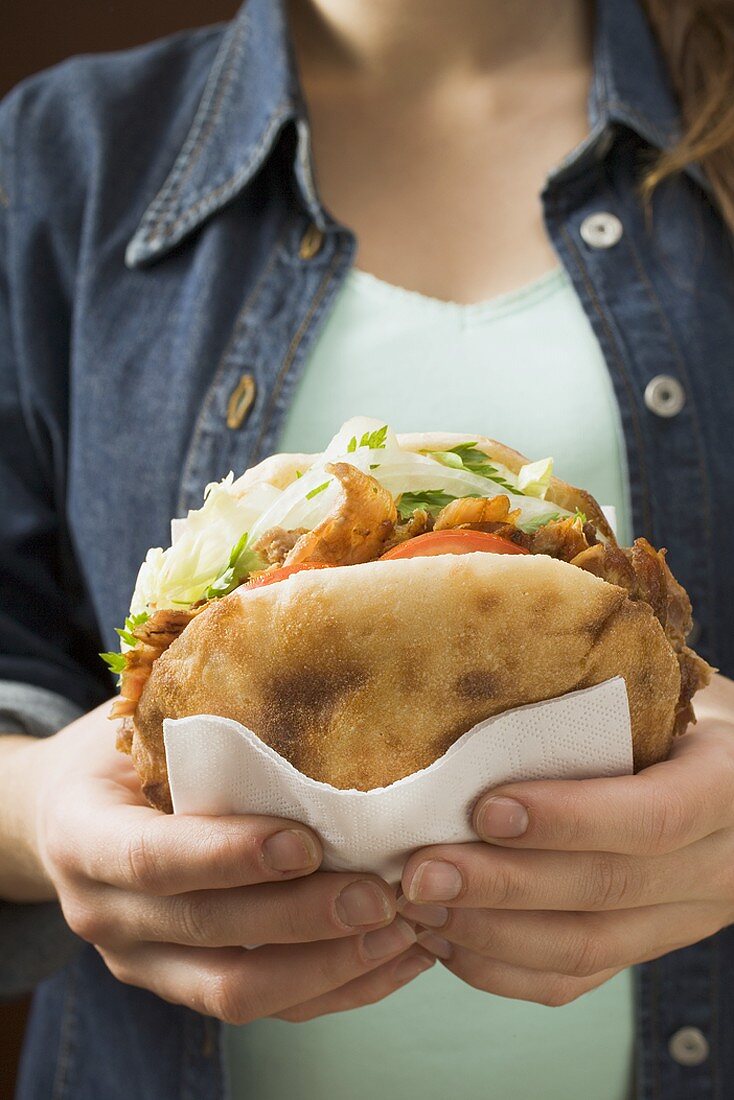 Junge Frau hält Döner Kebab in der Hand