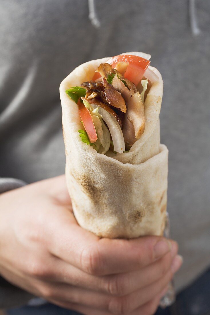 Hand holding a döner wrap