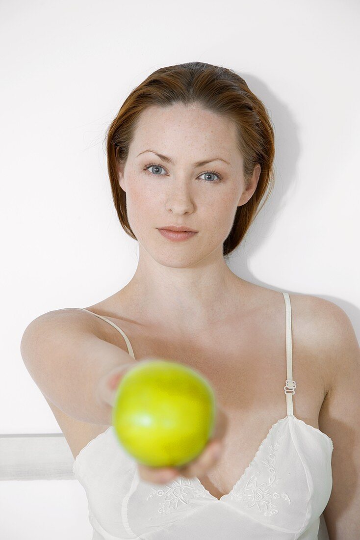 Young woman holding a green apple in her hand