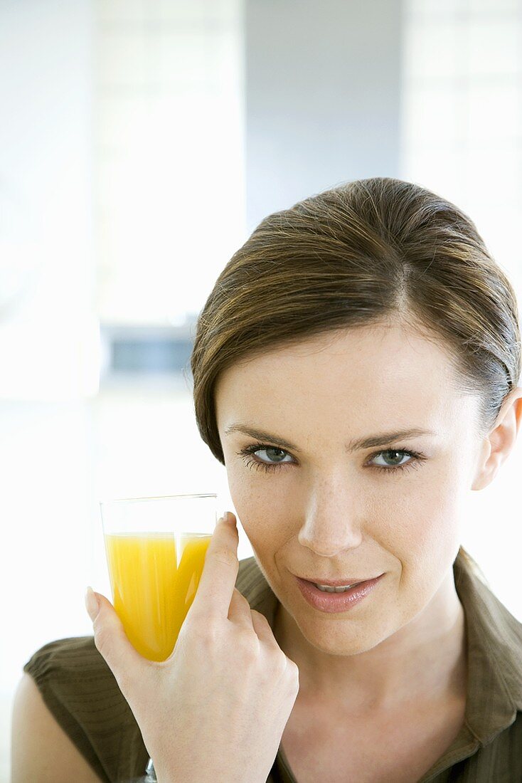 Junge Frau mit einem Glas Orangensaft