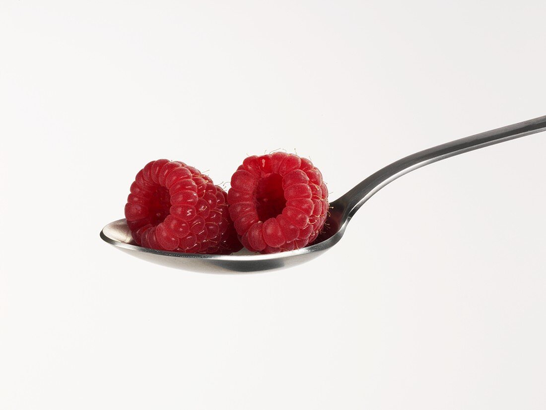 Two raspberries on a spoon