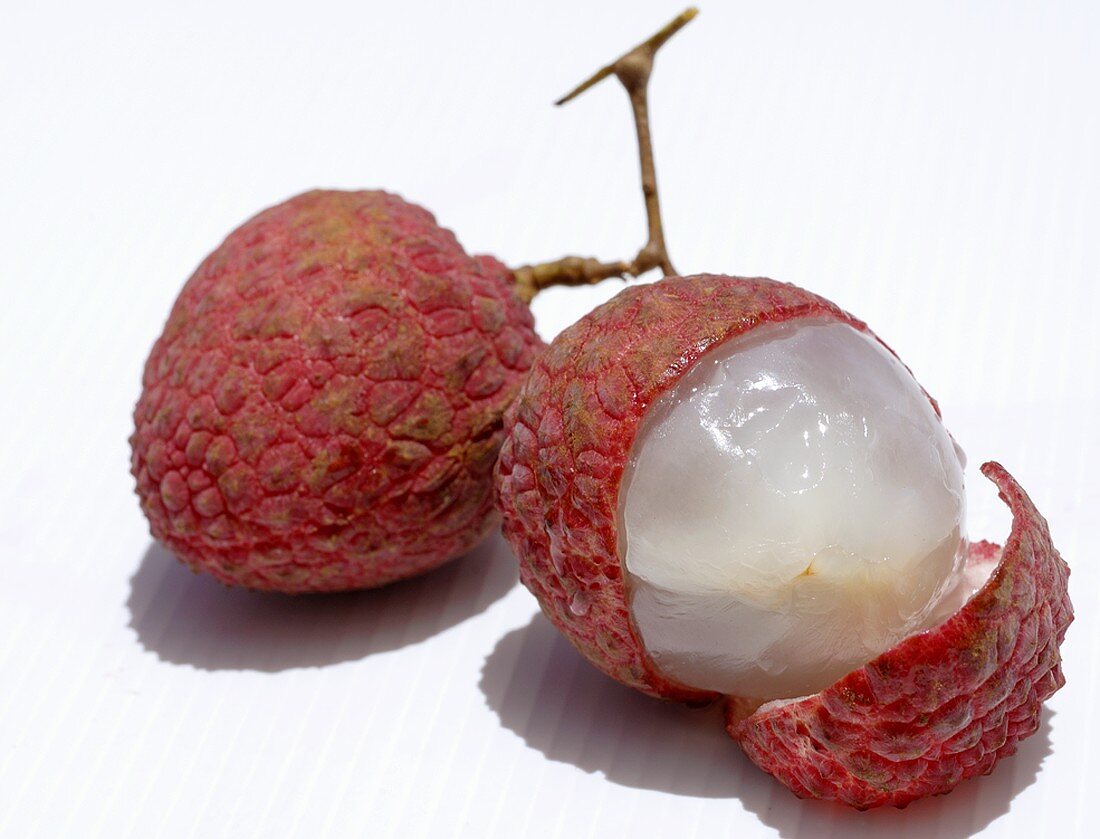 Two lychees, one partly peeled